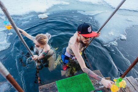 Young couple is swimming in an ice hole in the winterのeditorial素材