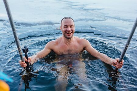 Novokuznetsk, Kemerovo region, Russia - 23 Feb, 2017 : White beaches of Siberia is an enterteiment activity where people playing beach games dressed in bikini in winter. A man swimming in an ice holeのeditorial素材