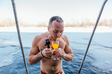 Novokuznetsk, Kemerovo region, Russia - 23 Feb, 2017 : White beaches of Siberia is an enterteiment activity where people playing beach games dressed in bikini in winter. A man swimming in an ice holeのeditorial素材
