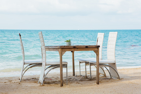 Restaurant on the tropical beach with white chaird and sea viewの写真素材