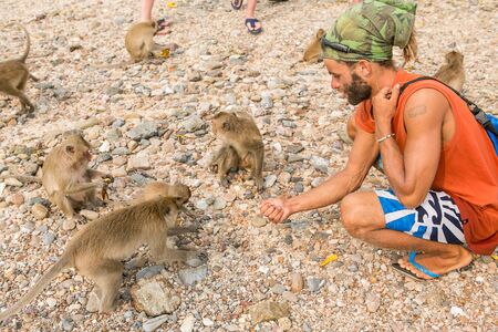 Tourists in Thailand with monkeys.
