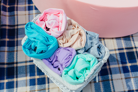 Colorful pastel clothes in a wicker basketの写真素材