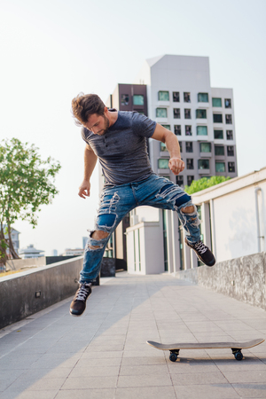 Skateboarder doing a skateboard trick ollie on the street of a cityの写真素材