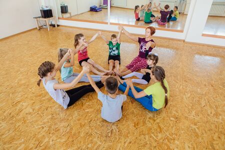 Novokuznetsk, Kemerovo region, Russia - 11 August 2018: Children of different age doing yoga exercises with teacher on yoga class.のeditorial素材