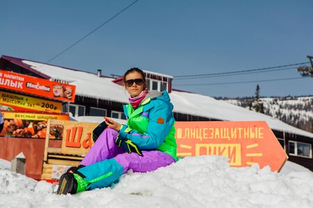 Sheregesh, Kemerovo Region, Russia - April 6, 2018 : Young woman snowboarder relaxing on the slopeのeditorial素材