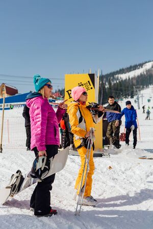 Sheregesh, Kemerovo Region, Russia - April 06, 2018 :: Snowboarders and mountain ski riders walking near the mountainのeditorial素材