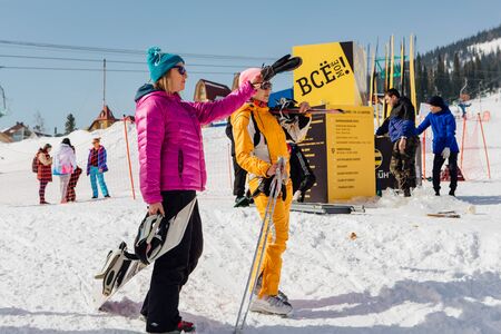 Sheregesh, Kemerovo Region, Russia - April 06, 2018 :: Snowboarders and mountain ski riders walking near the mountainのeditorial素材
