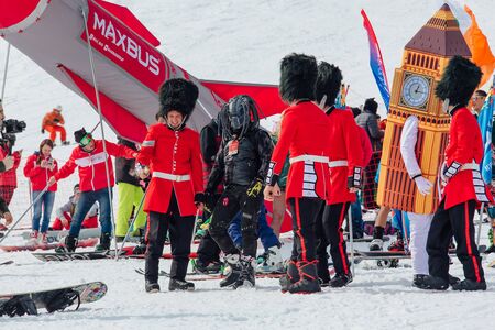 Sheregesh, Kemerovo region, Russia - April 22, 2017: Grelka Fest is a sports and entertainment activity for ski, snowboard riders in carnival costume. Young people in English royal guardsmen costumesのeditorial素材
