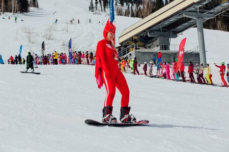 Sheregesh, Kemerovo region, Russia - April 7, 2018: Grelka Fest is a sports and entertainment activity for ski and snowboard riders in carnival costume. Young people in carnival costumes.のeditorial素材