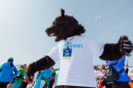 Sheregesh, Kemerovo region, Russia - April 7, 2018: Grelka Fest is a sports and entertainment activity for ski and snowboard riders in carnival costume. Man in the costume of a bear dancing on a slopeのeditorial素材