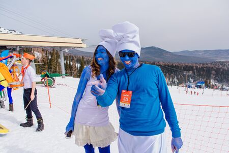 Sheregesh, Kemerovo region, Russia - April 7, 2018: Grelka Fest is a sports and entertainment activity for ski and snowboard riders in carnival costume. Young people in carnival costumes of Smurfs.のeditorial素材