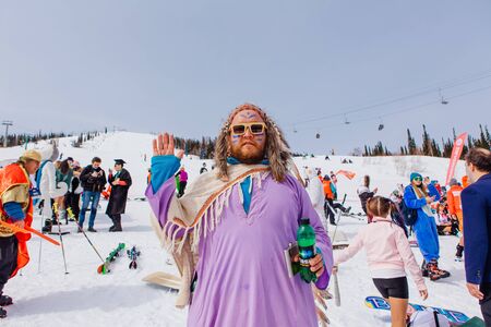 Sheregesh, Kemerovo region, Russia - April 7, 2018: Grelka Fest is a sports and entertainment activity for ski and snowboard riders in carnival costume. A man in costume of an Indian Chief.のeditorial素材