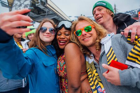 Sheregesh, Kemerovo region, Russia - April 14, 2018: Grelka Fest is a sports and entertainment activity for ski and snowboard riders in bikini. Happy smiling interbational company are huggingのeditorial素材