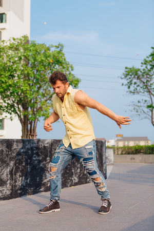 Young handsome man with beard dancing breakdance on the street.の写真素材