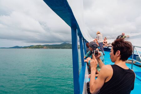 Surat Thai, Thailand - January 24, 2018: Tourists traveling on a ferry to the Koh Samui and Koh Phangan islands. People standing on the deck enjoing the tripのeditorial素材
