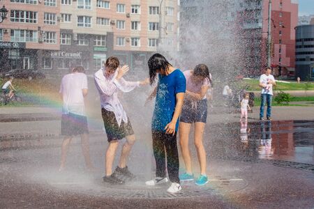 Novokuznetsk, Kemerovo Region, Russia - August 04, 2018: Happy teenagers splashing in a water of a city fountain and enjoying the cool streams of water in a hot day.のeditorial素材