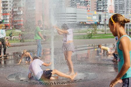 Novokuznetsk, Kemerovo Region, Russia - August 04, 2018: Happy teenagers splashing in a water of a city fountain and enjoying the cool streams of water in a hot day.のeditorial素材