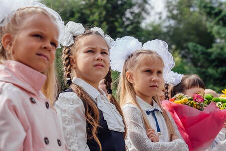 NOVOKUZNETSK, KEMEROVO REGION, RUSSIA - SEP, 1, 2018: Meeting with the first-grade pupils and teacher at schoolyard. The day of knowledge in Russia.のeditorial素材