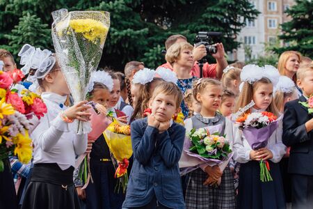 NOVOKUZNETSK, KEMEROVO REGION, RUSSIA - SEP, 1, 2018: Meeting with the first-grade pupils and teacher at schoolyard. The day of knowledge in Russia.のeditorial素材