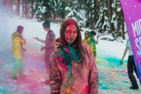 Sheregesh, Kemerovo region, Russia - April 06, 2019: Grelka Fest is a sports and entertainment activity for ski and snowboard riders in bikini. Young happy woman painted with Holi colorsのeditorial素材