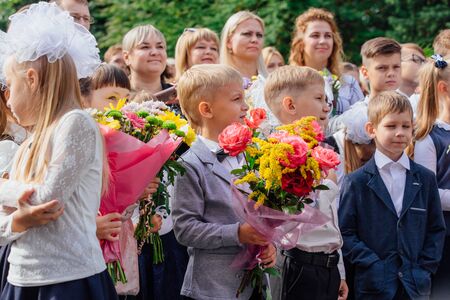 NOVOKUZNETSK, KEMEROVO REGION, RUSSIA - SEP, 1, 2018: Meeting with the first-grade pupils and teacher at schoolyard. The day of knowledge in Russia.のeditorial素材