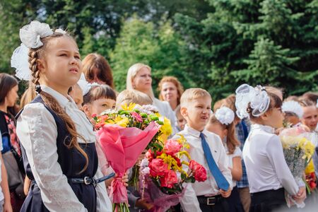 NOVOKUZNETSK, KEMEROVO REGION, RUSSIA - SEP, 1, 2018: Meeting with the first-grade pupils and teacher at schoolyard. The day of knowledge in Russia.のeditorial素材