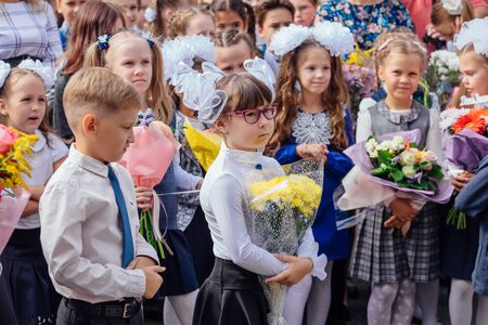 NOVOKUZNETSK, KEMEROVO REGION, RUSSIA - SEP, 1, 2018: Meeting with the first-grade pupils and teacher at schoolyard. The day of knowledge in Russia.のeditorial素材
