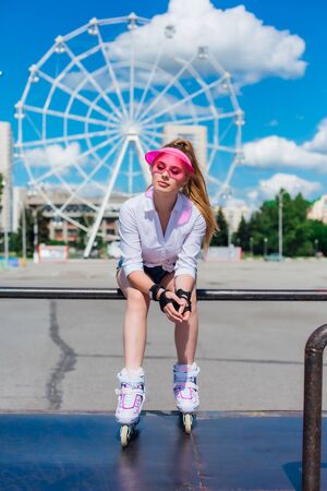 Portrait of an emotional girl in a pink cap visor wearing protective glovesの写真素材
