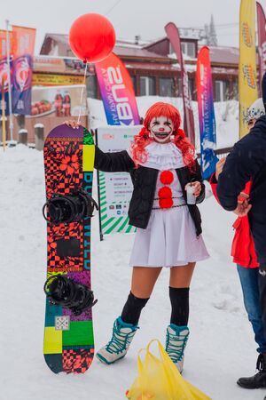 Sheregesh, Kemerovo region, Russia - April 06, 2019: Grelka Fest is a sports and entertainment activity for ski and snowboard riders in carnival costume. Young woman in carnival clown IT costume.のeditorial素材