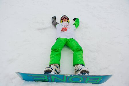 Sheregesh, Kemerovo region, Russia - April 06, 2019: Grelka Fest is a sports and entertainment activity for ski and snowboard riders in carnival costume. Boy snowboarder on the mountain slope.のeditorial素材