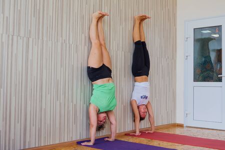 Novokuznetsk, Kemerovo region, Russia - September 07, 2019: Women of different ages doing yoga exercises with teacher on yoga class in cosy room.のeditorial素材