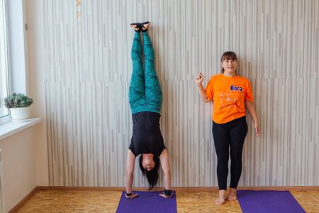 Novokuznetsk, Kemerovo region, Russia - September 07, 2019: Women of different ages doing yoga exercises with teacher on yoga class in cosy room.のeditorial素材