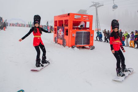 Sheregesh, Kemerovo region, Russia - April 06, 2019: Grelka Fest is a sports and entertainment activity for ski and snowboard riders in carnival costume. People in English royal guardsmen costumesのeditorial素材