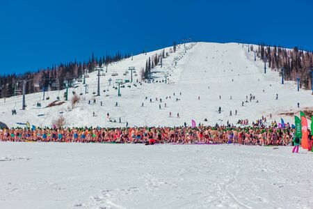Sheregesh, Kemerovo region, Russia - April 13, 2019: Grelka Fest is a sports and entertainment activity for ski and snowboard riders in bikini. Crowd of people riding snowboard and mountain skiのeditorial素材