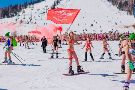 Sheregesh, Kemerovo region, Russia - April 13, 2019: Grelka Fest is a sports and entertainment activity for ski and snowboard riders in bikini. Crowd of people riding snowboard and mountain skiのeditorial素材