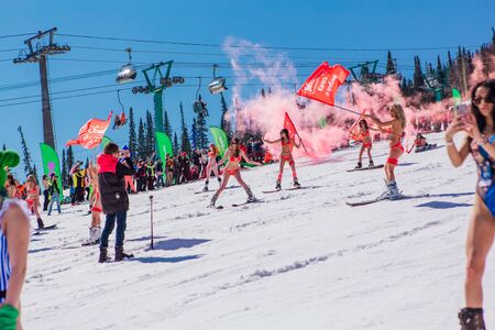 Sheregesh, Kemerovo region, Russia - April 13, 2019: Grelka Fest is a sports and entertainment activity for ski and snowboard riders in bikini. Crowd of people riding snowboard and mountain skiのeditorial素材