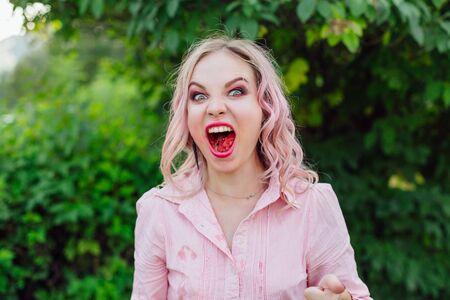 Beautiful young woman with pink hair enjoying sweet juicy watermelon