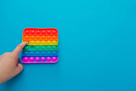 Hands of a woman playing with antistress pop it toy.の写真素材