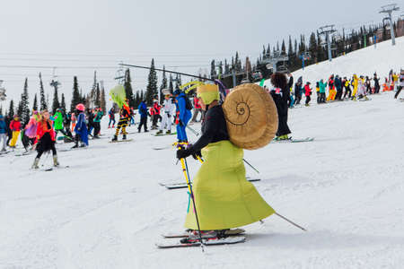 Sheregesh, Kemerovo region, Russia - April 03, 2021: Grelka Fest is a sports and entertainment activity for ski and snowboard riders. People in carnival costumes riding ski and snowboard.のeditorial素材