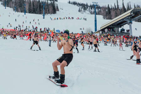 Sheregesh, Kemerovo region, Russia - April 17, 2021: Grelka Fest is a sports and entertainment activity for ski and snowboard riders in bikini. Crowd of people riding snowboard and mountain skiのeditorial素材
