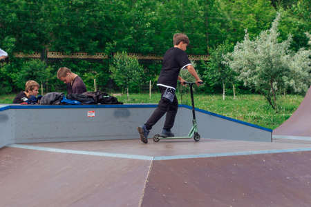 Novokuznetsk, Russia - July 19, 2021: Group of boys ride a scooter in an extreme park. Study of extreme sports on the open air.のeditorial素材