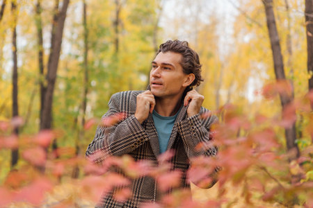 Tall handsome man walking in the autumn alleyの写真素材