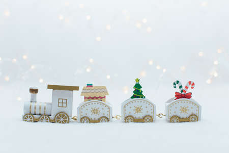 Wooden white christmas train on the white background with warm lightsの写真素材