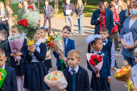 NOVOKUZNETSK, KEMEROVO REGION, RUSSIA - SEP, 1, 2021: Meeting with the first-grade pupils and teacher at schoolyard. The day of knowledge in Russia.のeditorial素材