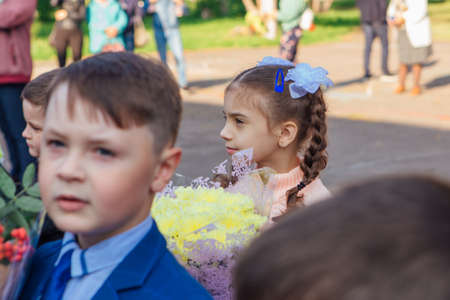 NOVOKUZNETSK, KEMEROVO REGION, RUSSIA - SEP, 1, 2021: Meeting with the first-grade pupils and teacher at schoolyard. The day of knowledge in Russia.のeditorial素材
