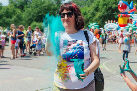 Novokuznetsk, Kemerovo region, Russia - June 12, 2022 :: Woman with colorful face painted with holi powder having fun outdoors.のeditorial素材