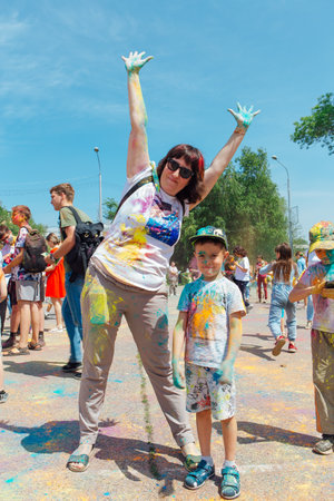 Novokuznetsk, Kemerovo region, Russia - June 12, 2022 :: Mother and son with colorful faces painted with holi powder having fun outdoors.のeditorial素材