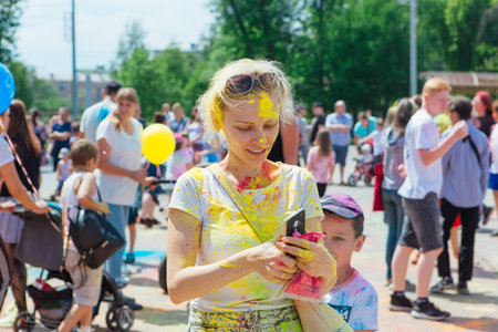 Novokuznetsk, Kemerovo region, Russia - June 12, 2022 :: Children with colorful faces painted with holi powder having fun outdoors.のeditorial素材