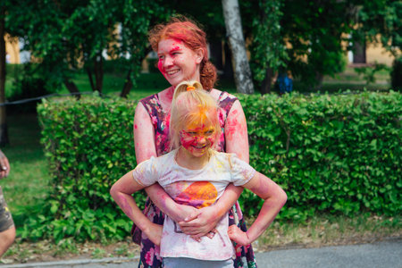 Novokuznetsk, Kemerovo region, Russia - June 12, 2022 :: Children with colorful faces painted with holi powder having fun outdoors.のeditorial素材