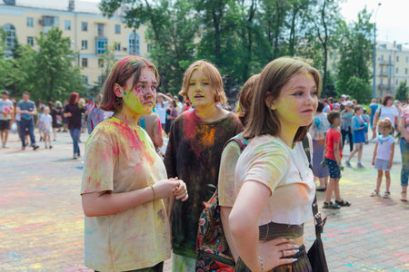 Novokuznetsk, Kemerovo region, Russia - June 12, 2022 :: Teenagers with colorful faces painted with holi powder having fun outdoors.のeditorial素材